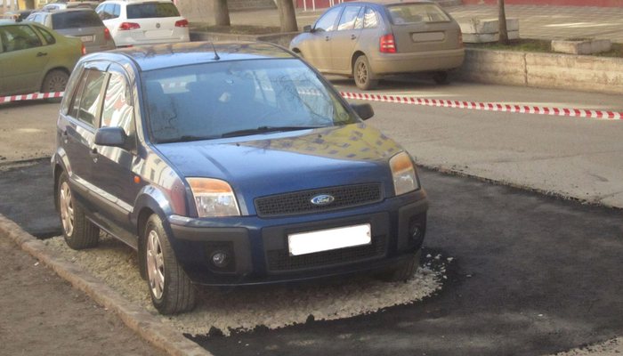 Дорожники шутят: в Кирове машину обложили асфальтом
