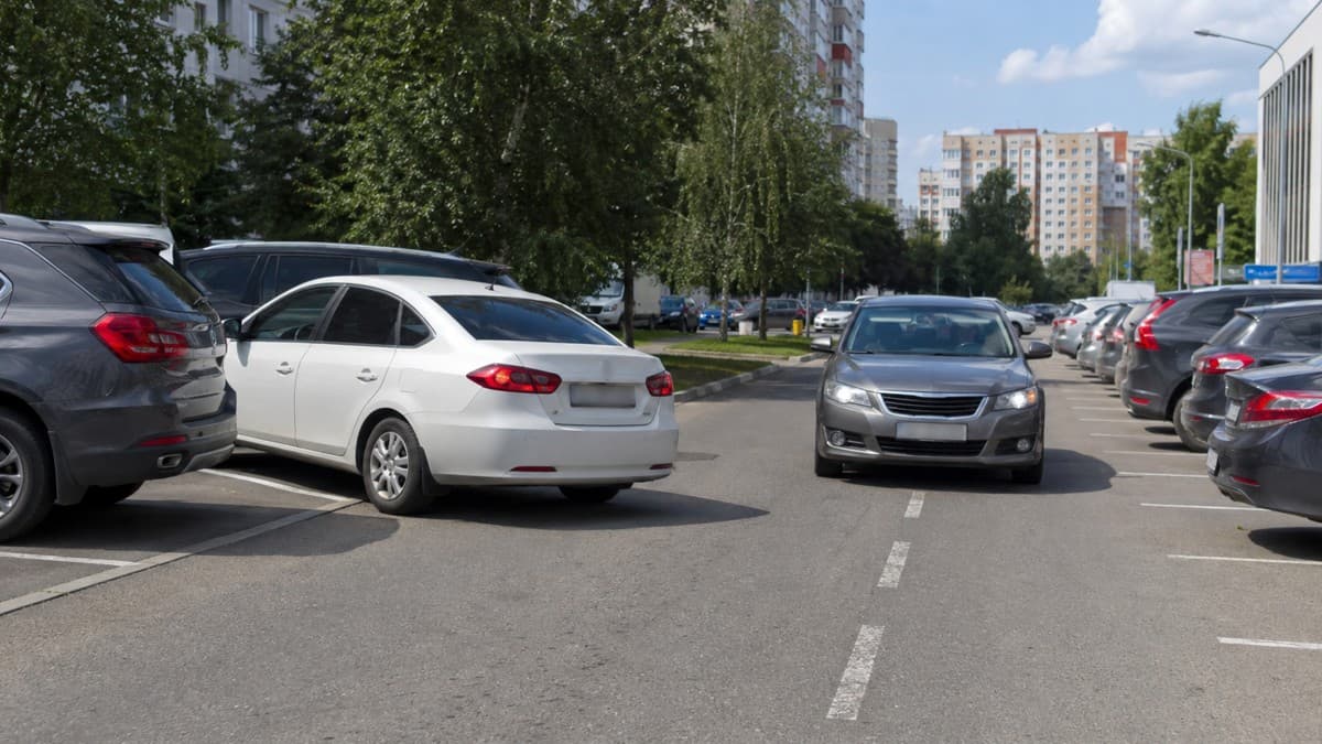 Один водитель сдаёт назад с парковочного места, второй едет прямо по проезду: кто обязан уступить по ПДД – проверьте себя