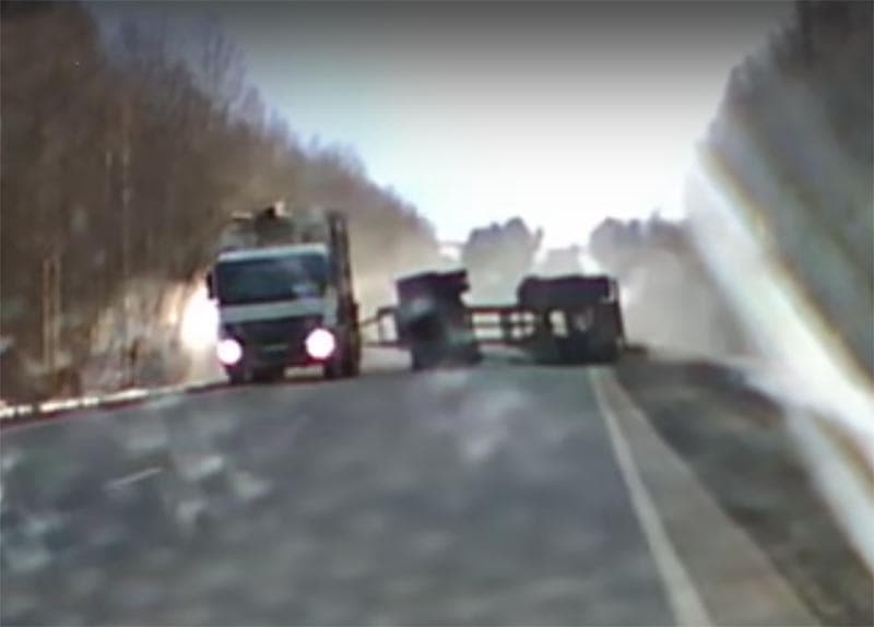 Лесовоз с грузом опрокинулся на трассе и едва не задел встречное авто. Момент попал на видео