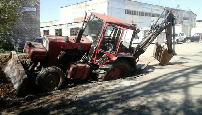 На улице Орджоникидзе в Кирове трактор провалился в яму