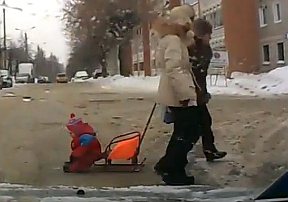 Ребенок выпал из санок на дорогу