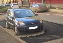 Дорожники шутят: в Кирове машину обложили асфальтом