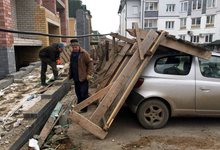 В Кирове сильный ветер обрушил забор на припаркованные машины